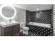 Bathroom featuring patterned tile, a vessel sink, and a modern, round mirror at 3384 Cranston Cir, Highlands Ranch, CO 80126