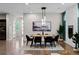 Elegant dining room with modern lighting, stylish decor, and beautiful hardwood floors at 3384 Cranston Cir, Highlands Ranch, CO 80126
