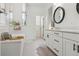 Light-filled bathroom with double vanity and large soaking tub at 10534 Oncilla Ln, Lone Tree, CO 80124