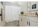 Bright bathroom featuring white vanity, black hardware, and shower with patterned curtain at 10534 Oncilla Ln, Lone Tree, CO 80124