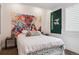 A bedroom with white bedding, a colorful tapestry, and a window with natural light at 10534 Oncilla Ln, Lone Tree, CO 80124