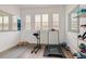 Bright room featuring exercise equipment and large windows with shutters at 10534 Oncilla Ln, Lone Tree, CO 80124