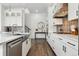 Modern kitchen with sleek white cabinetry, stainless steel appliances, and a center island with stainless sink at 10534 Oncilla Ln, Lone Tree, CO 80124