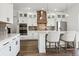 Modern kitchen with white cabinetry, stainless steel appliances, center island with bar seating, and stylish lighting fixtures at 10534 Oncilla Ln, Lone Tree, CO 80124
