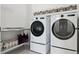 A bright laundry room featuring an LG washer and dryer, stainless steel shelf, and overhead storage baskets at 10534 Oncilla Ln, Lone Tree, CO 80124
