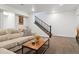 A Gathering room featuring a neutral couch, wood coffee table, and stairs leading upstairs at 10534 Oncilla Ln, Lone Tree, CO 80124
