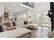 Bright and airy living room featuring soaring ceilings, large windows, and hardwood floors, open to the kitchen at 10534 Oncilla Ln, Lone Tree, CO 80124