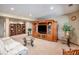 View of a finished basement with a large entertainment center, white couch, and glass table at 5542 Ponderosa Dr, Parker, CO 80134