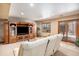 View of a finished basement featuring a large entertainment center, a white sectional couch, and natural light at 5542 Ponderosa Dr, Parker, CO 80134