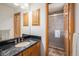Bathroom boasts vanity with black countertop and enclosed glass shower, complemented by wood trim at 5542 Ponderosa Dr, Parker, CO 80134