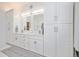 Modern bathroom featuring a double vanity, white cabinets, and ample storage space at 5542 Ponderosa Dr, Parker, CO 80134