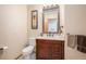 Charming powder room with a wood vanity, decorative mirror, and neutral paint at 5542 Ponderosa Dr, Parker, CO 80134