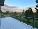 Large deck offering scenic views of lush greenery and a stunning sunset at 5542 Ponderosa Dr, Parker, CO 80134