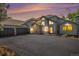 Beautiful exterior of home with three-car garage and a well-maintained asphalt driveway at sunset at 5542 Ponderosa Dr, Parker, CO 80134
