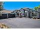 Inviting exterior of a home with a brick facade, grand windows, and a wide driveway on a sunny day at 5542 Ponderosa Dr, Parker, CO 80134