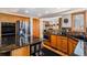 Modern kitchen with a center island, stainless steel appliances, and adjacent dining area with a fireplace at 5542 Ponderosa Dr, Parker, CO 80134