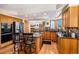 Spacious kitchen with oak cabinets, granite countertops, an island with barstool seating and modern appliances at 5542 Ponderosa Dr, Parker, CO 80134