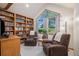 Cozy living room featuring a wall of built-in bookshelves and two comfortable armchairs near a large window at 5542 Ponderosa Dr, Parker, CO 80134