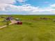Scenic aerial view of a charming home in a vast green field under a beautiful, partly cloudy sky at 28495 La Donna Vista Ln, Elizabeth, CO 80107