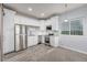 Well-lit kitchen features stainless steel appliances, white cabinets, and gray wood-look flooring at 28495 La Donna Vista Ln, Elizabeth, CO 80107