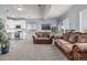 Spacious living area featuring neutral carpet, two sofas, and an adjoining kitchen with white cabinets at 28495 La Donna Vista Ln, Elizabeth, CO 80107
