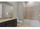 Bathroom features shower over tub, neutral tile, single vanity, and large mirror at 10114 Atlanta St, Parker, CO 80134