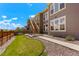 Back exterior view of a multi-story home with a grass and rock yard and wooden staircase at 10114 Atlanta St, Parker, CO 80134