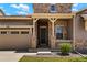 Inviting home exterior featuring a covered porch, stone columns, and a well-manicured lawn, perfect for curb appeal at 10114 Atlanta St, Parker, CO 80134