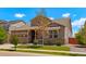 Lovely home exterior showcasing a covered porch, stone details, and a lush green lawn under a bright blue sky at 10114 Atlanta St, Parker, CO 80134