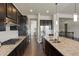 Contemporary kitchen featuring a large island with granite countertops, stainless steel appliances, and dark cabinetry at 10114 Atlanta St, Parker, CO 80134