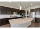 Modern kitchen with granite countertops, stainless steel appliances, dark cabinetry and stylish pendant lighting at 10114 Atlanta St, Parker, CO 80134
