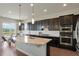 Stylish kitchen featuring granite countertops, stainless steel appliances, dark cabinets, and modern pendant lights at 10114 Atlanta St, Parker, CO 80134