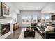 Bright living room with hardwood floors, fireplace, and large windows offering pleasant views, furnished with a plush sectional at 10114 Atlanta St, Parker, CO 80134