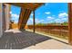 A covered patio with a view of a wood fence and blue skies with white clouds at 10114 Atlanta St, Parker, CO 80134