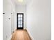 View of a hallway featuring hardwood floors and a glass panel front door at 2841 Stout St, Denver, CO 80205