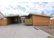 Modern home featuring wooden siding, a carport, and a well-kept concrete driveway and green grass at 5350 E 66Th Way, Commerce City, CO 80022