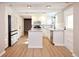 Bright kitchen with white cabinets, an island, stainless steel appliances, and modern light fixtures at 5350 E 66Th Way, Commerce City, CO 80022