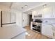 Bright kitchen featuring white cabinets, stainless steel appliances, and a view to another room at 5350 E 66Th Way, Commerce City, CO 80022