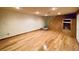 Finished basement with wooden floors, steps up to the next level, and built-in shelving at 7194 S Himalaya Way, Centennial, CO 80016