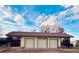 Three-car garage featuring individual automatic doors, a clay tile roof, and gravel driveway at 7194 S Himalaya Way, Centennial, CO 80016