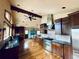 Spacious kitchen with stainless steel appliances, a stone range hood, wood beam, and hardwood floors at 7194 S Himalaya Way, Centennial, CO 80016