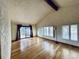 Bright living room with hardwood floors, a vaulted ceiling, and multiple windows allowing ample natural light at 7194 S Himalaya Way, Centennial, CO 80016