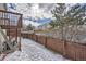 Fenced backyard with snow covered ground and wooden fence at 12460 S Hollow Creek Ct, Parker, CO 80134