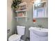Small bathroom with white vanity, toilet and floating shelves at 12460 S Hollow Creek Ct, Parker, CO 80134