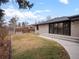 A spacious backyard featuring a well-kept lawn and a brick house with large sliding glass doors to a patio at 3049 S Vine St, Denver, CO 80210
