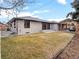 Wide backyard with a brick home and a covered patio space, ideal for outdoor relaxation and entertainment at 3049 S Vine St, Denver, CO 80210