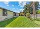 Large backyard with a well-kept lawn, a covered outdoor kitchen, and mature trees at 3049 S Vine St, Denver, CO 80210
