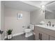Bathroom featuring gray tile floor, updated vanity, toilet and mirror at 3049 S Vine St, Denver, CO 80210