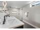 Modern bathroom featuring a double sink vanity, walk-in shower, and herringbone tile floors at 3049 S Vine St, Denver, CO 80210