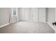 Bright bedroom with soft carpet, natural light, and sliding closet doors at 3049 S Vine St, Denver, CO 80210